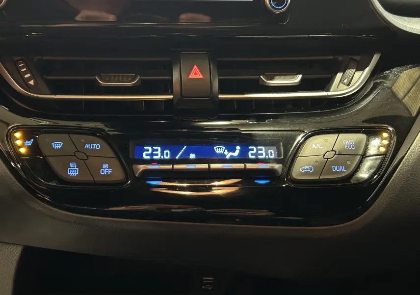 Vue rapprochée de la console centrale du Toyota C-HR Hybride 2021, affichant la climatisation digitale à 23°C.