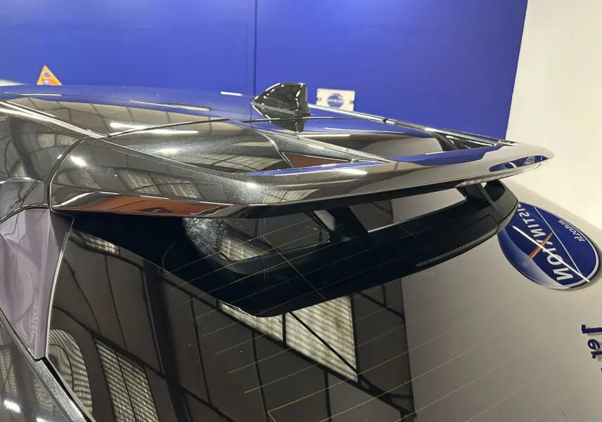 Vue rapprochée de l'arrière supérieur du Toyota C-HR Hybride noir métal, mettant en valeur l'aileron et l'antenne requin.