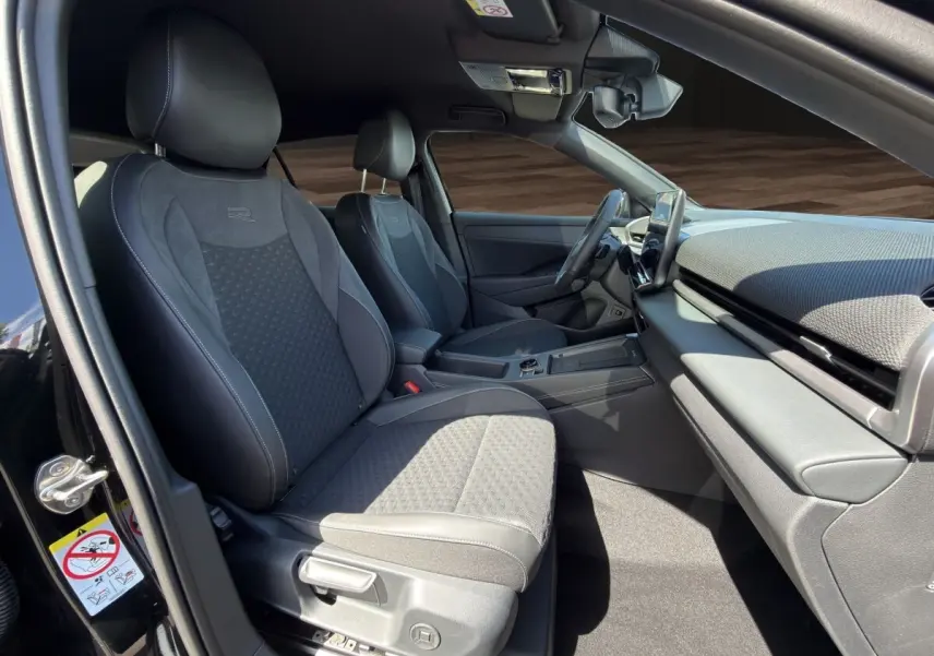 Vue intérieure côté conducteur du Volkswagen T-Roc noir 2026, mettant en valeur les sièges R-Line et le tableau de bord moderne.