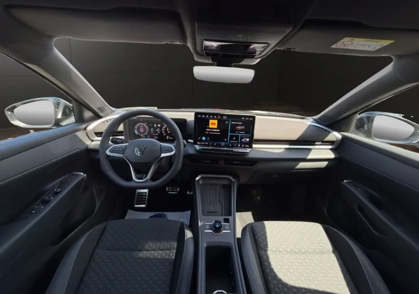 Vue intérieure avant du Volkswagen T-Roc noir 2026, avec tableau de bord numérique et écran tactile central.