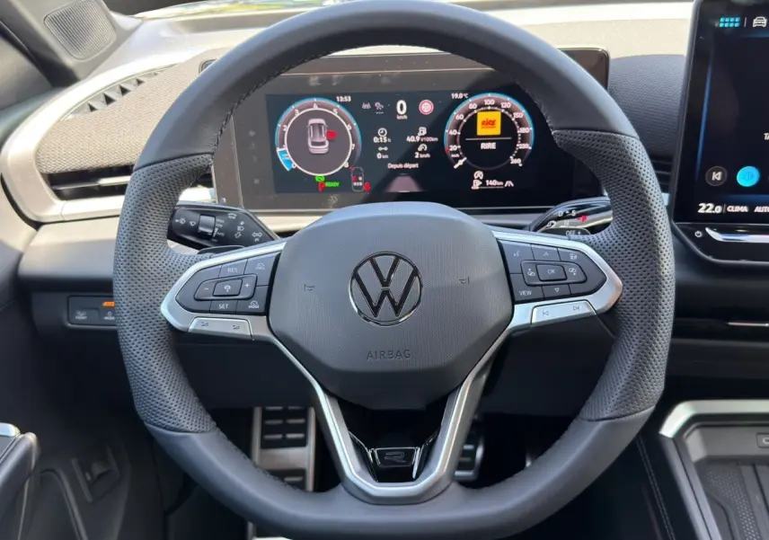 Vue rapprochée du volant cuir noir de Volkswagen T-Roc 2026 avec tableau de bord numérique et commandes multifonctions.