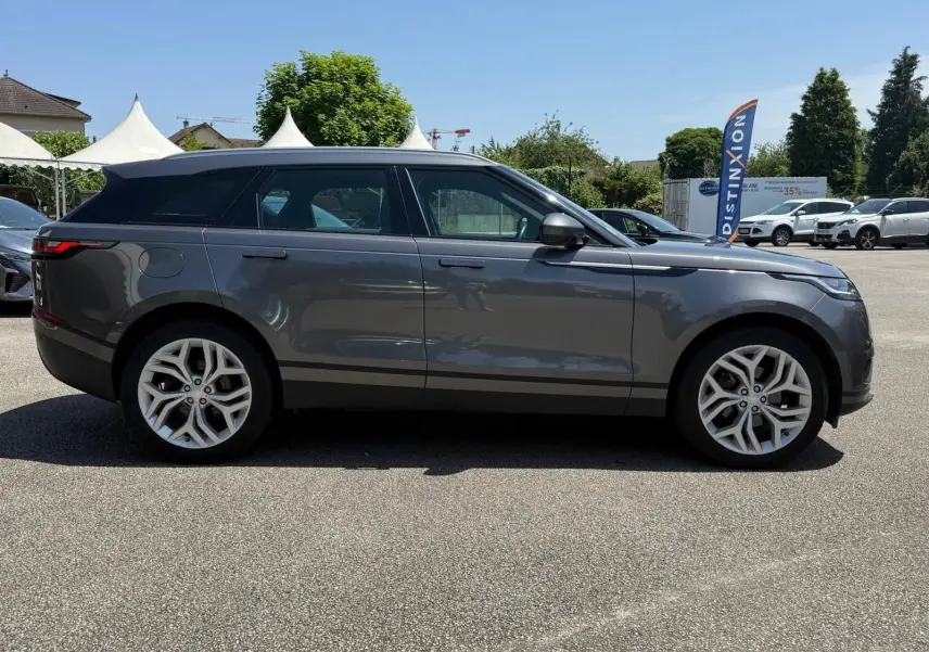 Profil latéral droit d'un Range Rover Velar gris 2019, soulignant ses jantes alliage et lignes épurées.