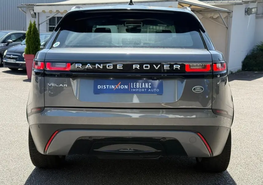 Vue arrière d'un Range Rover Velar gris 2019 avec feux LED distinctifs et logo Land Rover visible.