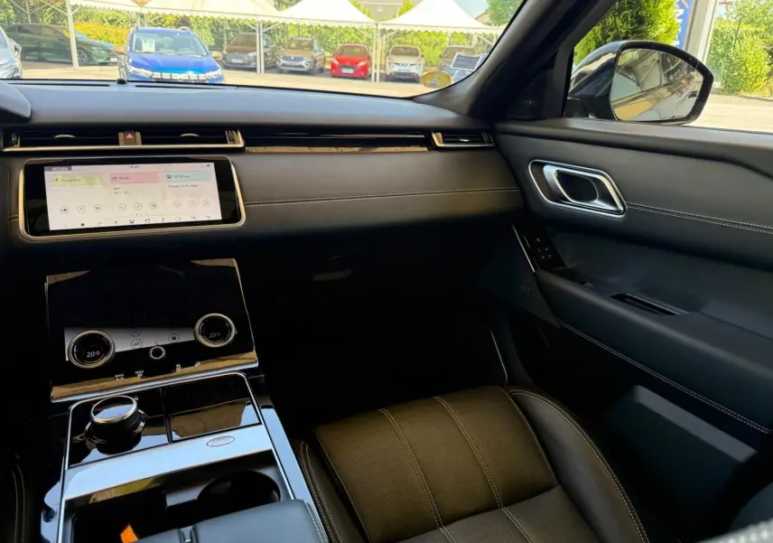 Intérieur du Range Rover Velar 2019 en cuir gris, vue côté passager mettant en valeur la console tactile et les finitions cuir Windsor.