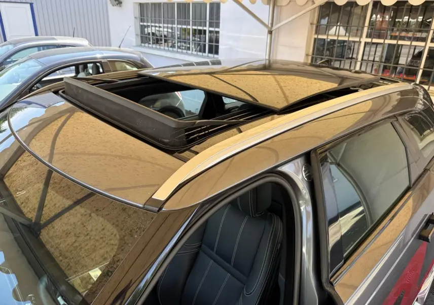 Vue plongeante sur le toit ouvrant et siège avant gauche d'un Range Rover Velar gris métallisé 2019.