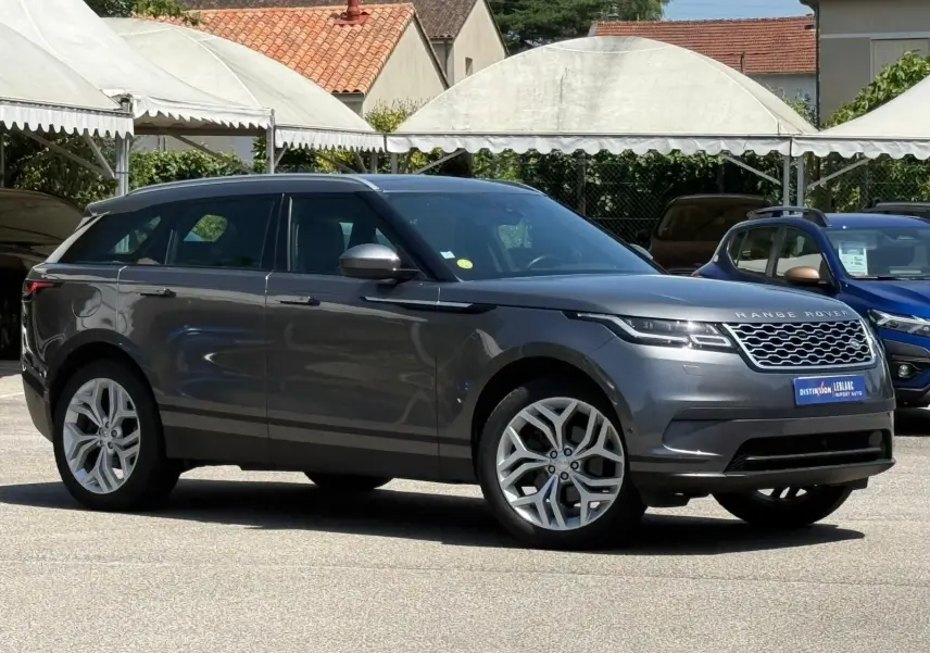 Range Rover Velar gris en vue profil côté gauche, soulignant ses jantes alliage et sa silhouette élégante.