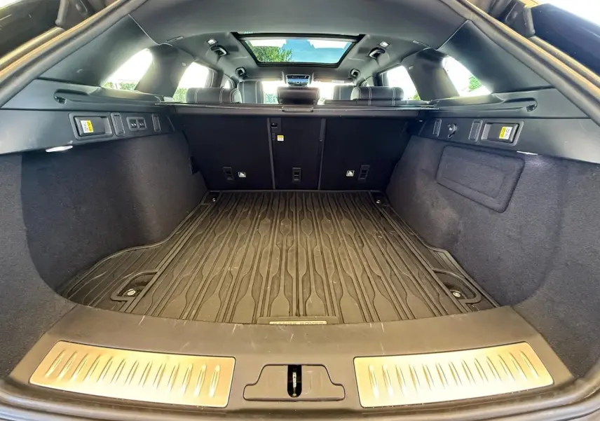 Coffre spacieux du Range Rover Velar gris 2019 vu de l'arrière avec plancher caoutchouc et toit panoramique.