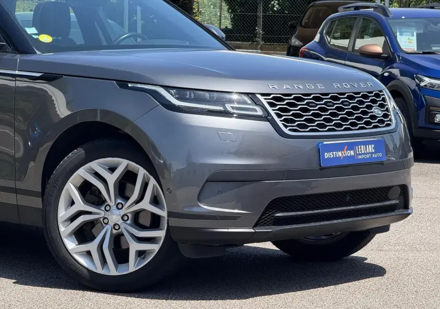 Vue 3/4 avant d'un Range Rover Velar gris métallisé mettant en valeur sa calandre distinctive et ses jantes alliage.