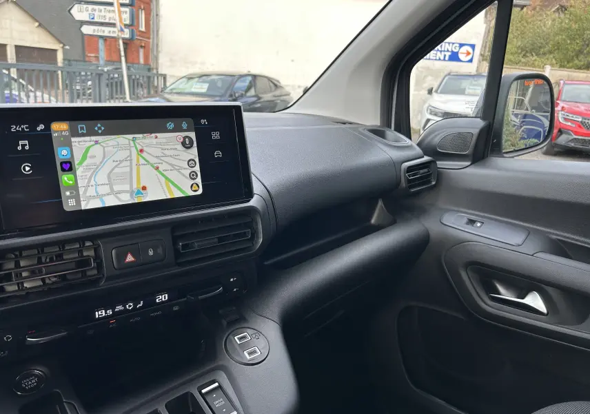 Intérieur du Peugeot Partner Fourgon 2025, tableau de bord moderne avec écran tactile et commandes climatisation, vue côté passager.