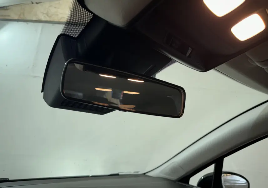 Rétroviseur intérieur et partie supérieure du pare-brise d'une Renault Clio gris clair vue de l'habitacle côté conducteur.