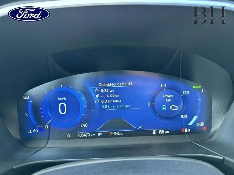 Vue rapprochée du tableau de bord numérique bleu du Ford Kuga 2023, affichant vitesse, puissance et informations de bord.