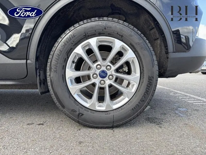 Gros plan sur la roue avant droite du Ford Kuga noir Agate Métallisée avec jante alliage et pneu Bridgestone.