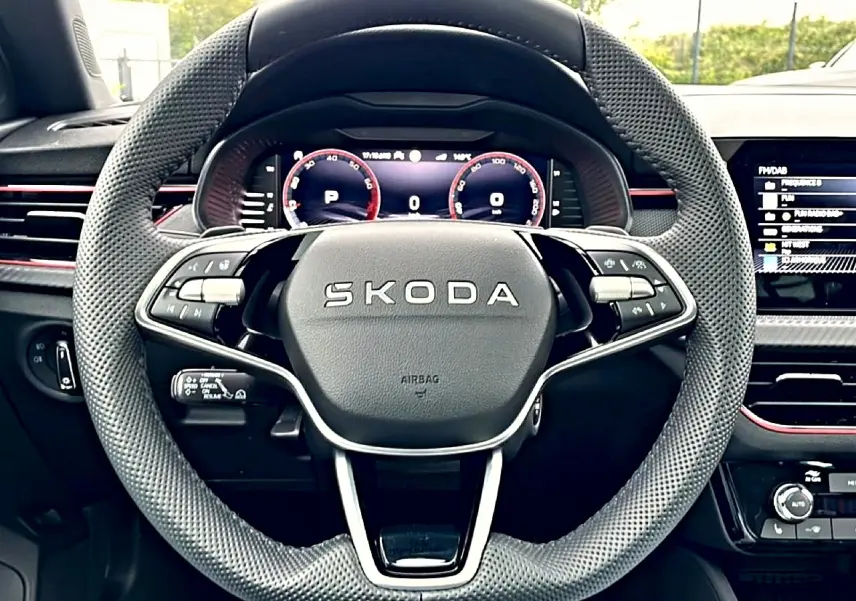 Vue frontale du volant en cuir perforé gris foncé du Skoda Kamiq 2026 avec tableau de bord numérique et inserts rouges.