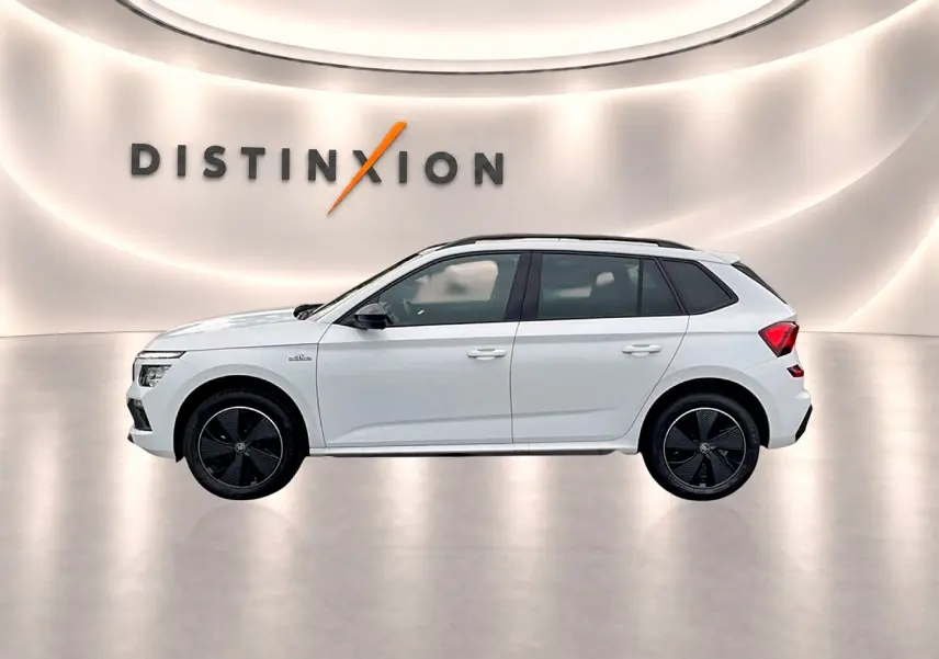 Profil droit du Skoda Kamiq blanc nacré avec jantes noires et toit panoramique en arrière-plan lumineux.