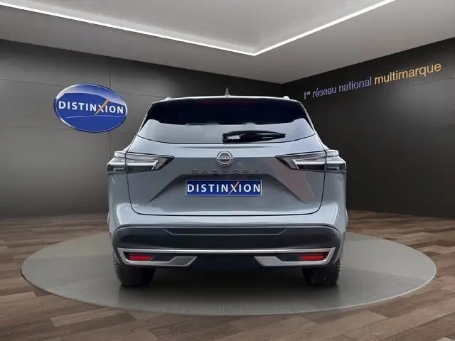 Vue arrière d'un Nissan Qashqai gris foncé 2025 avec hayon électrique, dans un showroom Distinxion.