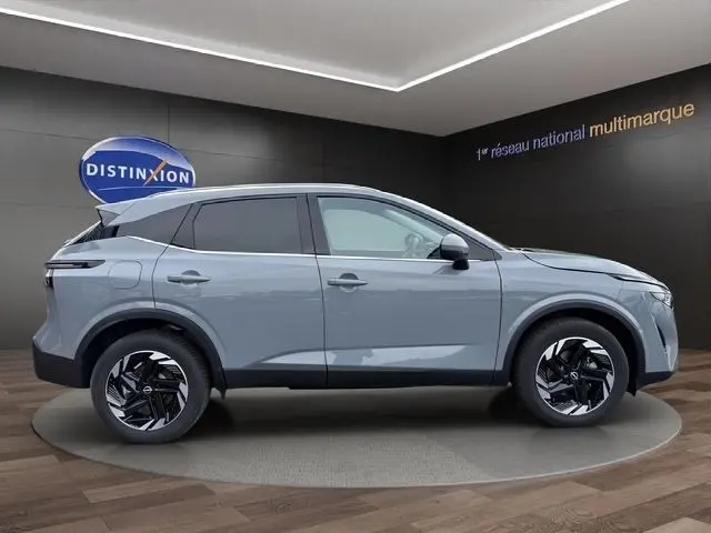 Vue de profil côté gauche du Nissan Qashqai gris foncé 2025 avec jantes noires et hayon électrique ouvert.