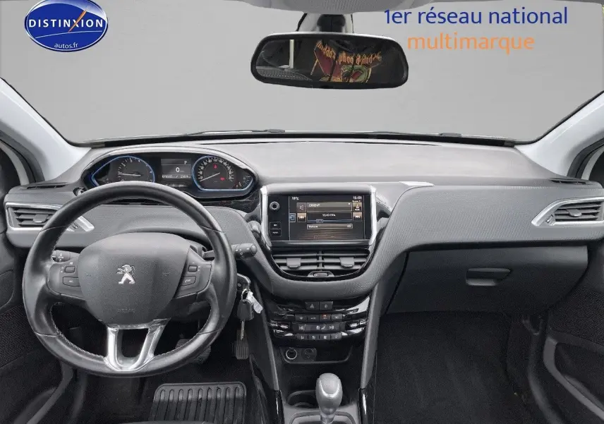 Intérieur de la Peugeot 2008 blanc nacré de 2015, vue frontale sur le tableau de bord et volant cuir noir.