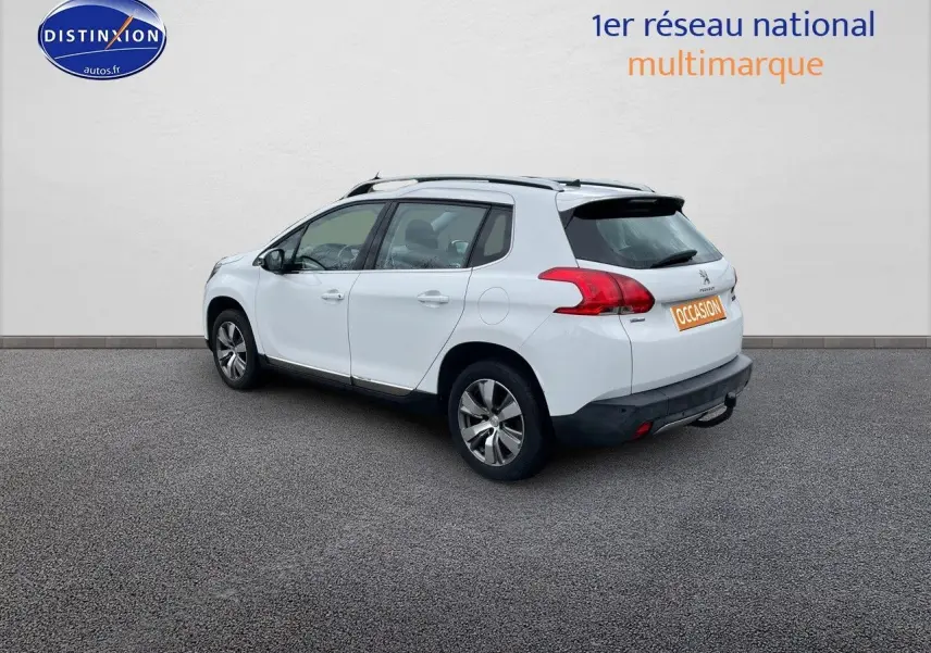 Peugeot 2008 blanc nacré vue de trois quarts arrière côté gauche, avec jantes alliage et toit noir contrasté.