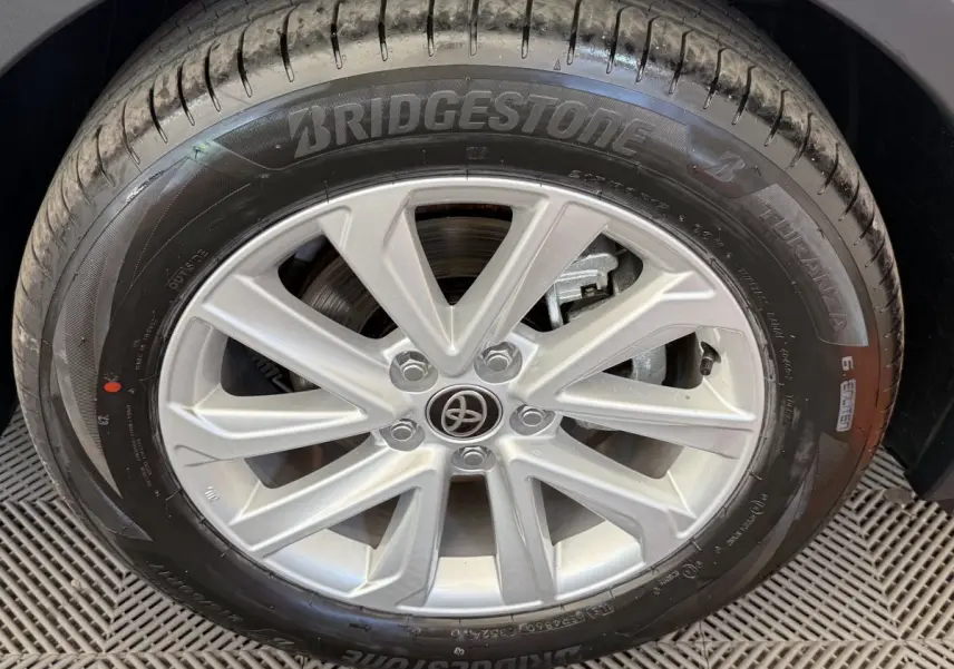 Gros plan sur la jante alliage argentée et pneu Bridgestone du Toyota C-HR 1.8 Hybride blanc, côté droit.