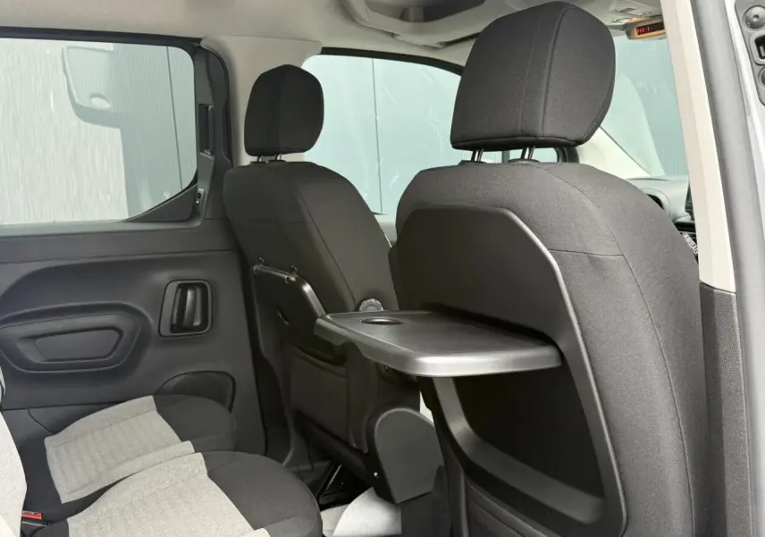 Vue intérieure côté droit des sièges arrière gris foncé et clair du Citroën Berlingo Multispace 2026 avec tablette escamotable.