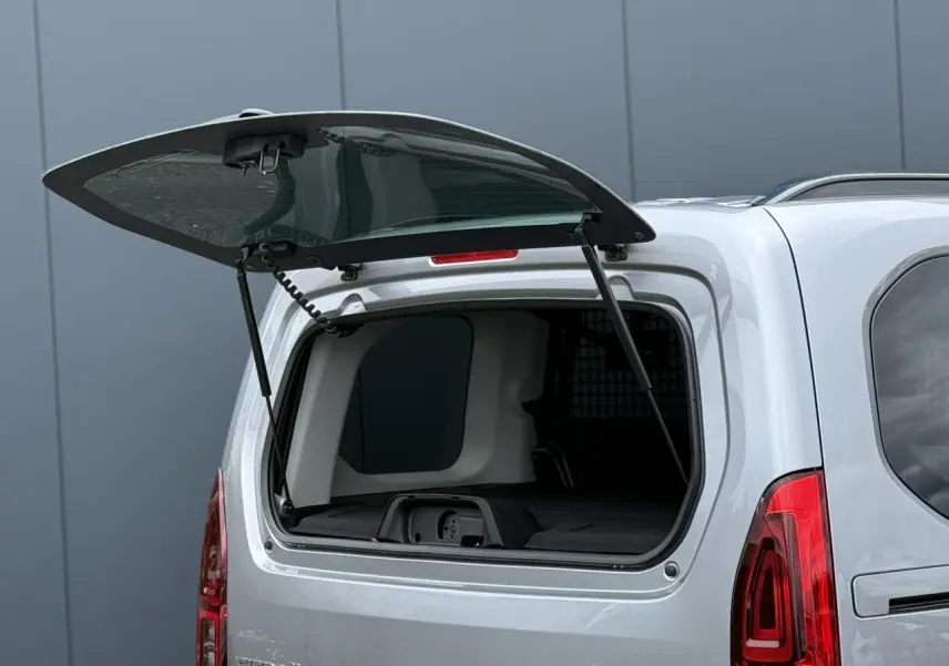 Vue arrière du Citroën Berlingo gris acier avec lunette arrière ouvrante relevée et intérieur partiellement visible.