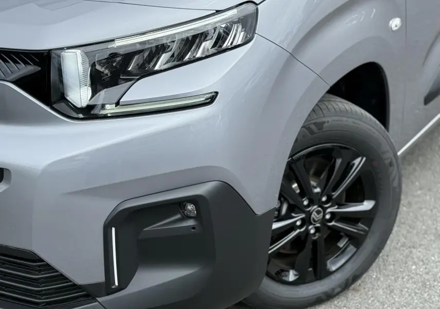 Gros plan sur l'avant droit gris acier du Citroën Berlingo Multispace 2026 avec jante alliage noire et phare LED.