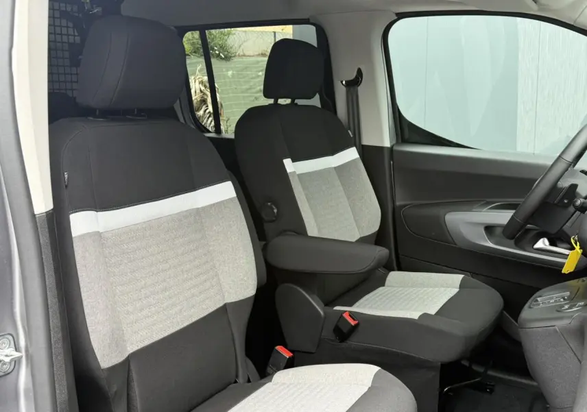 Vue intérieure côté droit du Citroën Berlingo Multispace 2026, sièges avant bicolores gris clair et noir avec accoudoirs.