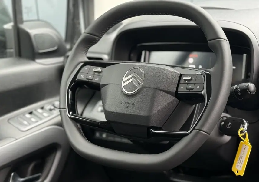 Gros plan sur le volant cuir multifonctions noir du Citroën Berlingo Multispace 2026, avec commandes intégrées.