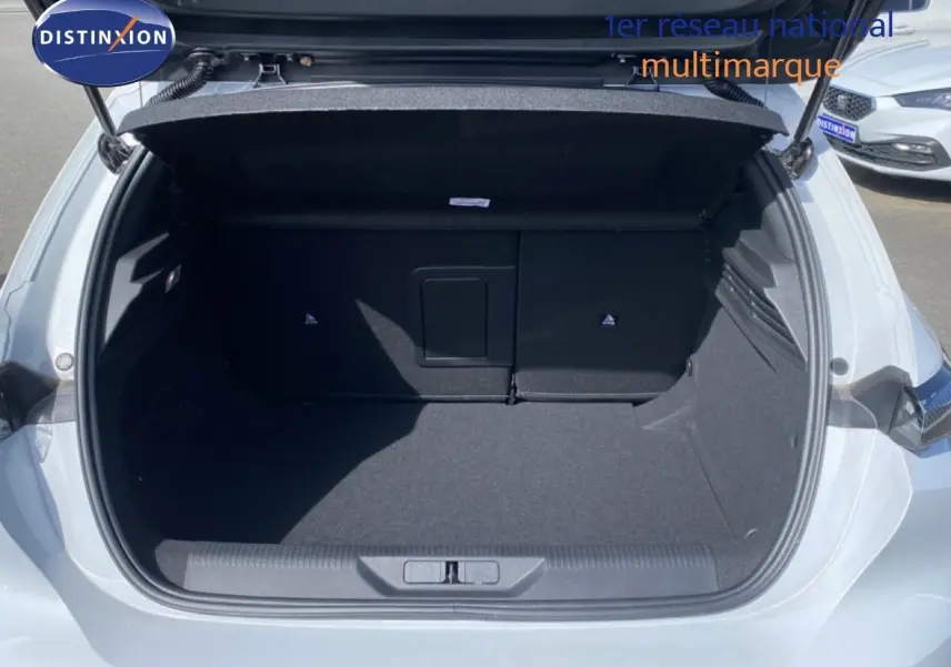 Coffre ouvert vu de l'arrière d'une Peugeot 308 blanche Okenite Metal, montrant un espace de chargement vide et propre.