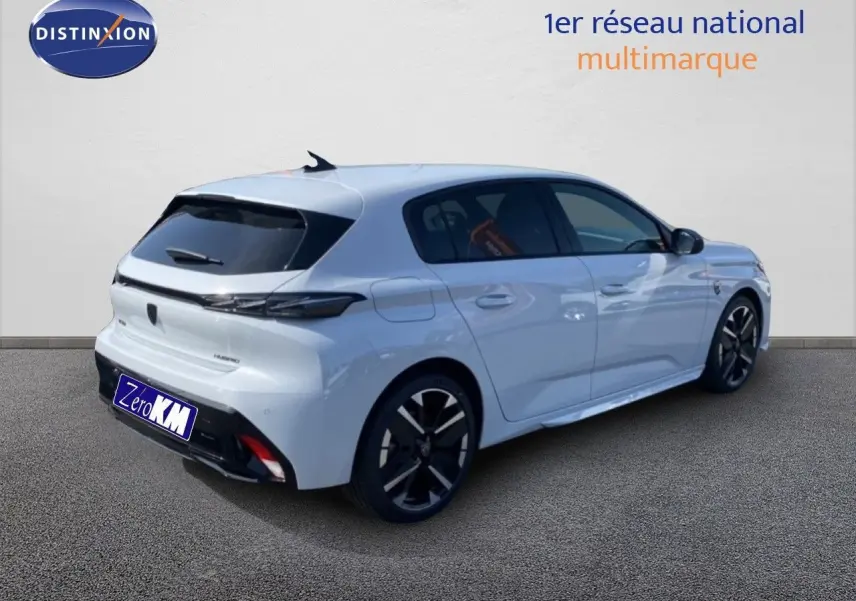 Vue 3/4 arrière droite d'une Peugeot 308 blanche Okenite Hybrid 2026 avec jantes noires et vitres teintées.