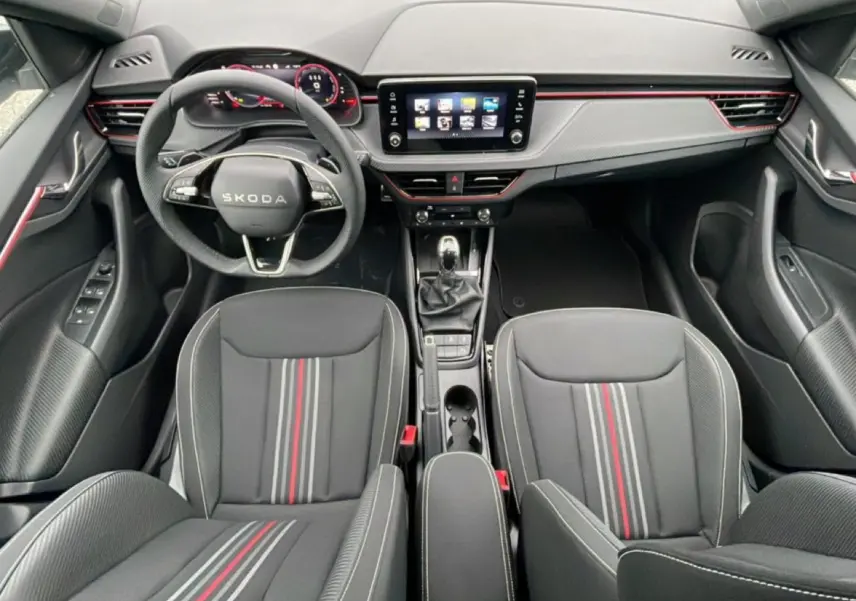Intérieur noir du Skoda Kamiq Monte Carlo 2026 vu de dessus, avec sièges sport à bandes rouges et volant multifonction.