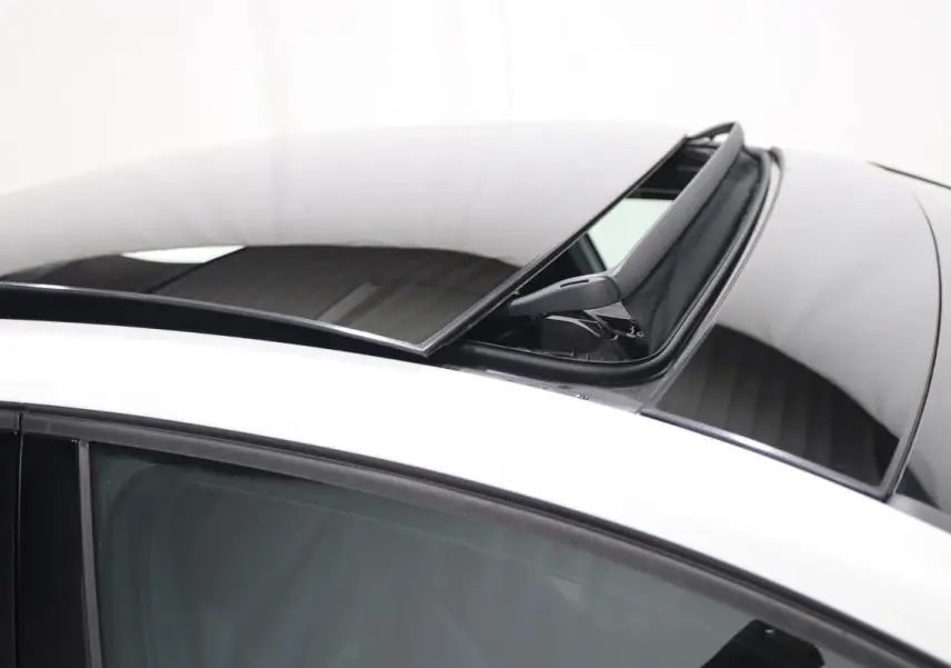 Détail du toit panoramique ouvert sur une Volkswagen Golf blanche, vue de dessus côté gauche.