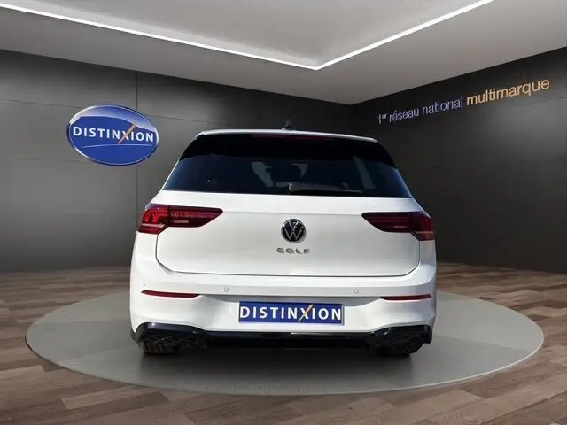 Vue arrière d'une Volkswagen Golf blanche 2.0 TDI 150 DSG7 R-Line avec toit panoramique et caméra 360 en showroom.