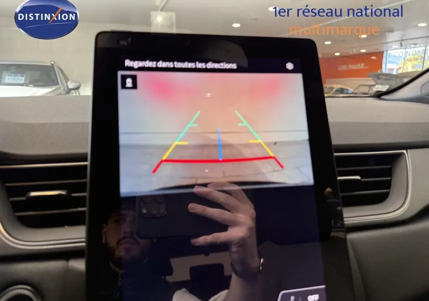 Écran central affichant la caméra de recul dans l’habitacle d’un Renault Captur gris Cassiopée métal avec toit gris, vue de face.