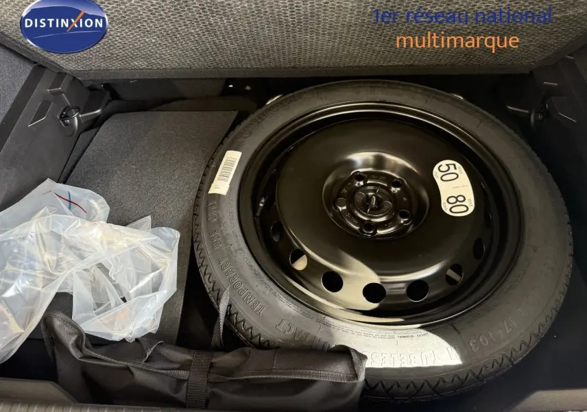 Vue rapprochée de la roue de secours noire dans le coffre du Renault Captur gris Cassiopée Métal.