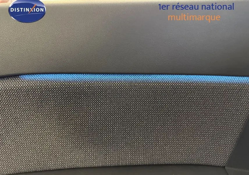 Détail intérieur montrant la texture grise et la bande bleue du tissu sur la porte d’un Renault Captur 2025 hybride.