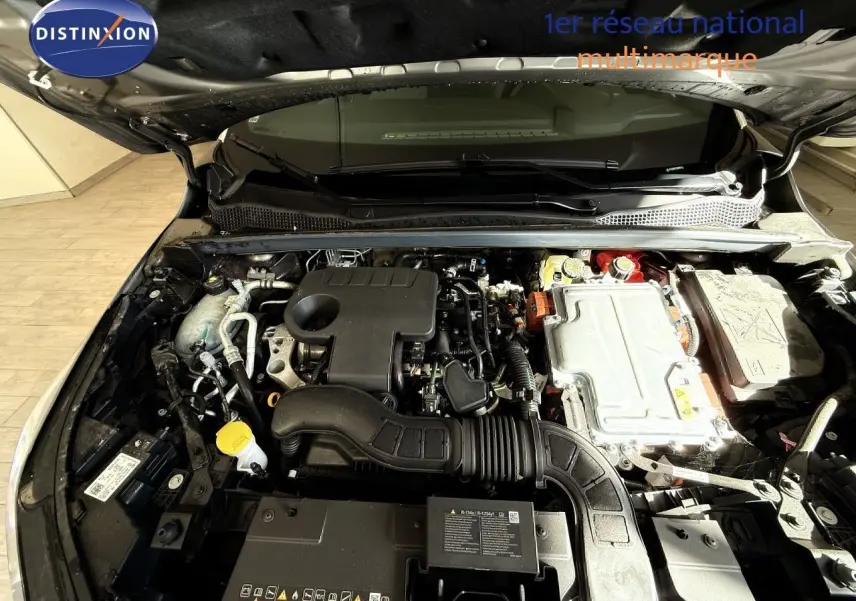 Moteur hybride Renault Captur 1.6 E-TECH vu de dessus sous le capot ouvert, détails des composants visibles.