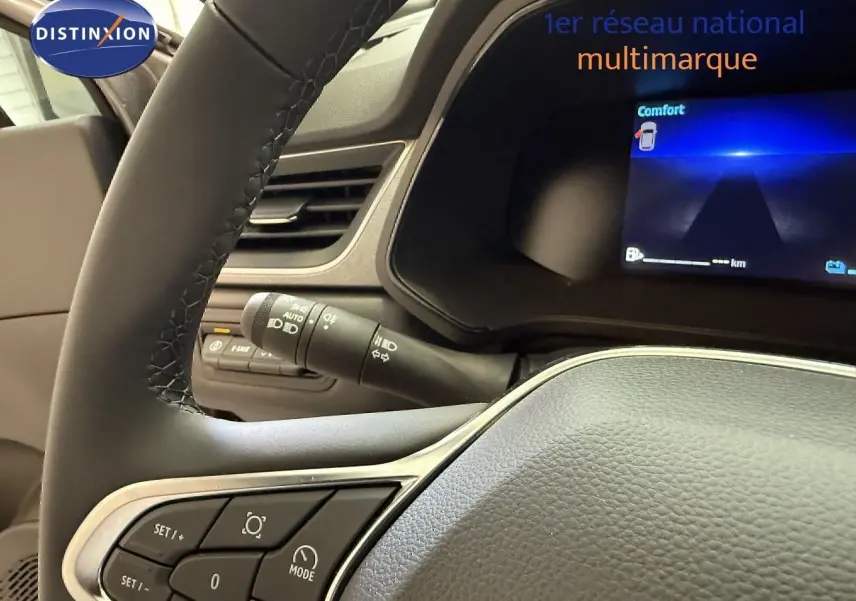 Vue rapprochée du volant et du tableau de bord numérique du Renault Captur gris Cassiopée, affichant le mode Confort.