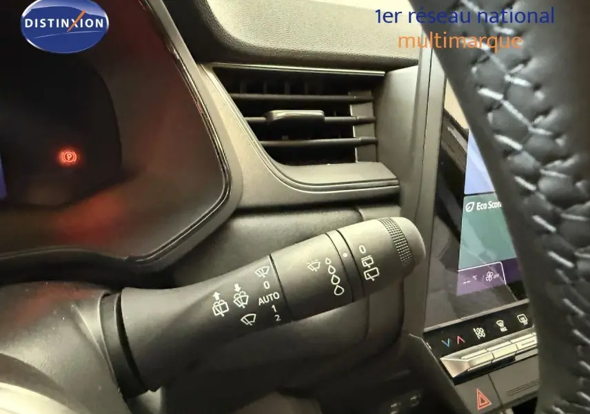 Vue intérieure rapprochée du commodo d'essuie-glace à gauche du volant dans un Renault Captur gris Cassiopée 2025.