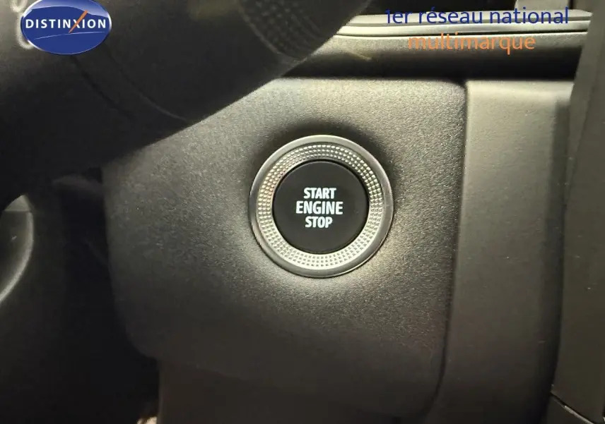 Gros plan sur le bouton Start Engine Stop du tableau de bord intérieur du Renault Captur gris Cassiopée 2025.