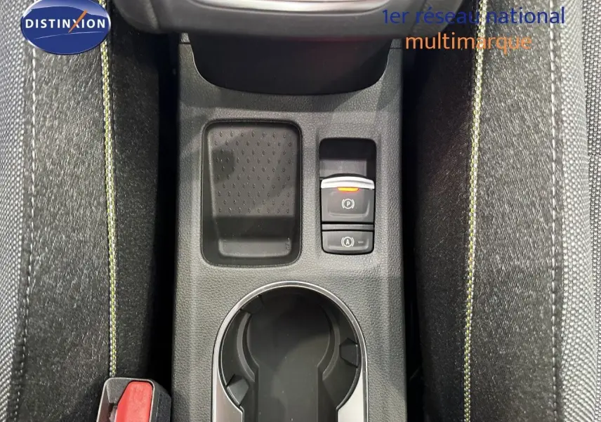 Vue plongeante sur la console centrale du Renault Captur gris Cassiopée, avec bouton frein à main électronique et surpiqûres jaunes.