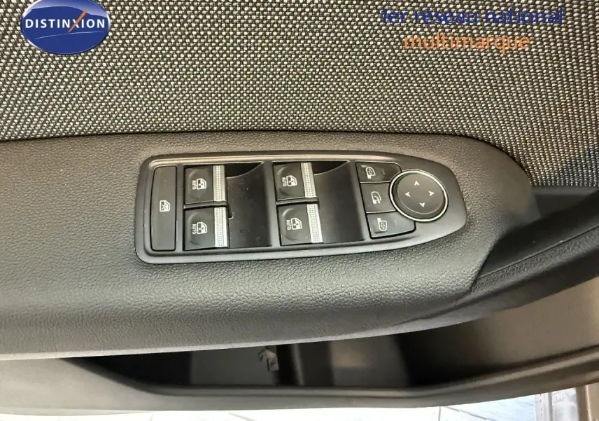 Gros plan sur les commandes des vitres électriques et rétroviseurs du côté gauche d'une Renault Captur gris cassiopée métal 2025.