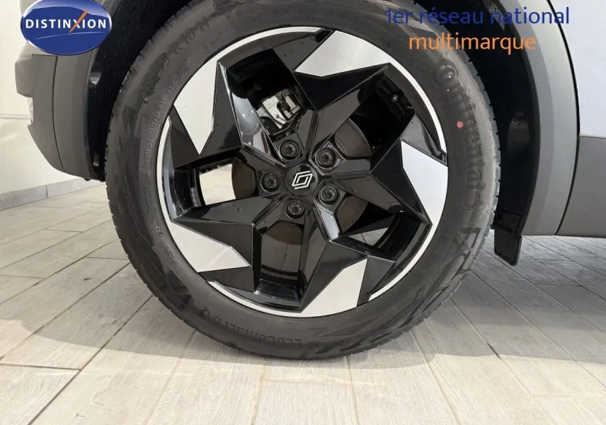 Gros plan sur la roue avant droite du Renault Captur 2025, jante bi-ton noire et argent au design géométrique.