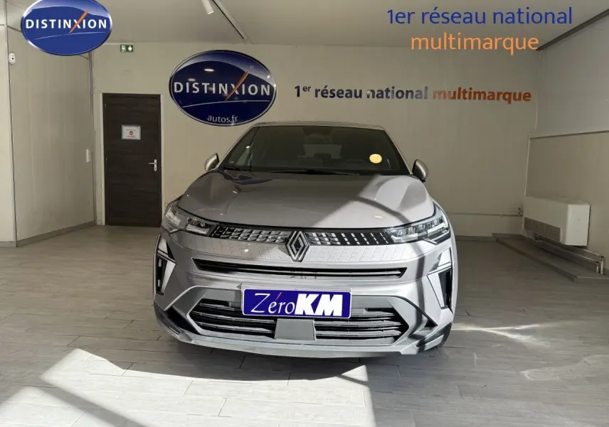 Vue frontale d'un Renault Captur 2025 gris Cassiopée métal avec toit gris, dans un showroom lumineux.