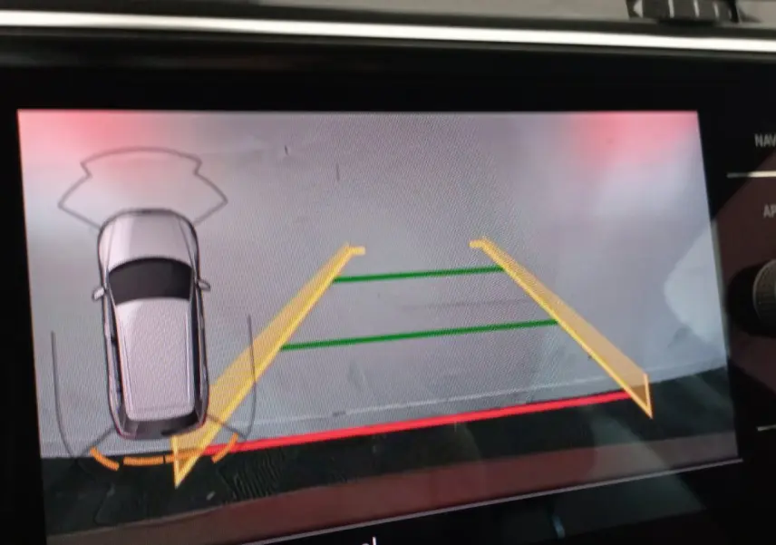Affichage écran tactile montrant la caméra de recul du Volkswagen Tiguan Allspace marron en vue aérienne arrière.