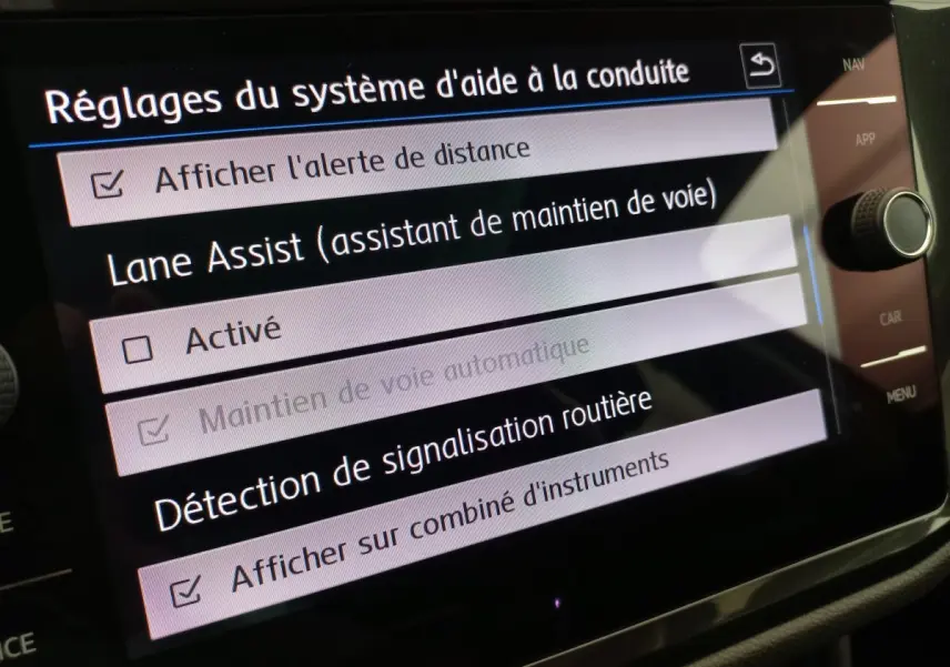 Écran tactile du système d'aide à la conduite du Volkswagen Tiguan Allspace, affichant les réglages Lane Assist et signalisation routière.
