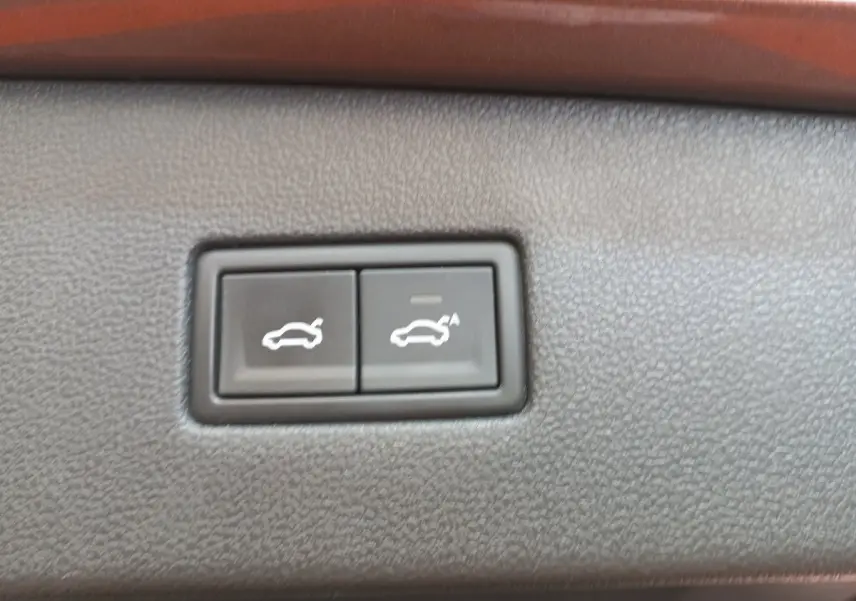 Gros plan sur les boutons d'ouverture et de fermeture électrique du coffre du Volkswagen Tiguan Allspace marron.