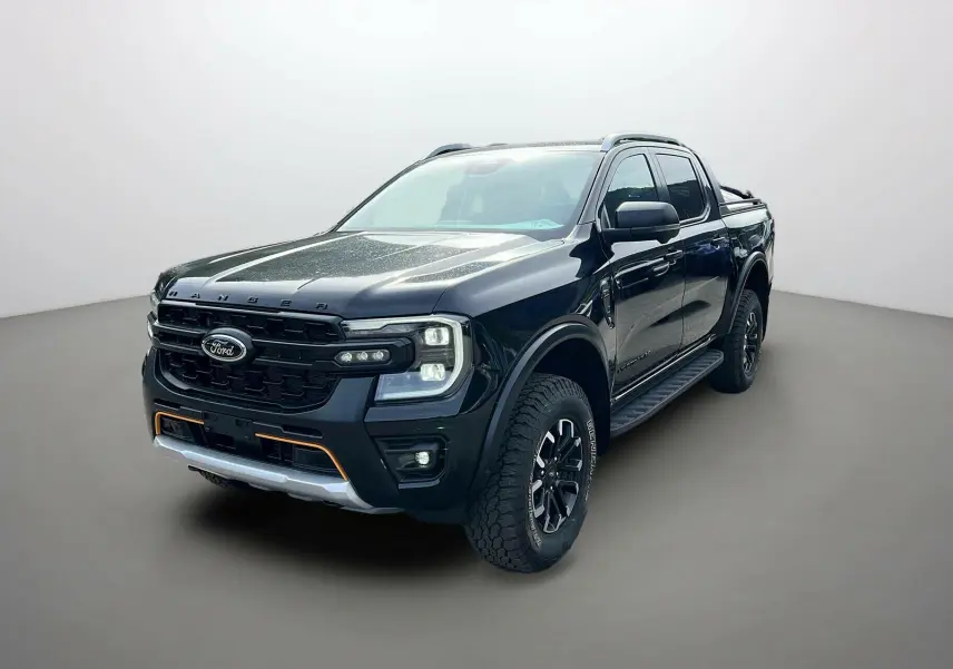Ford Ranger 2025 noir agate en 3/4 avant droit, avec calandre noire et éclairage auxiliaire orange distinctif.