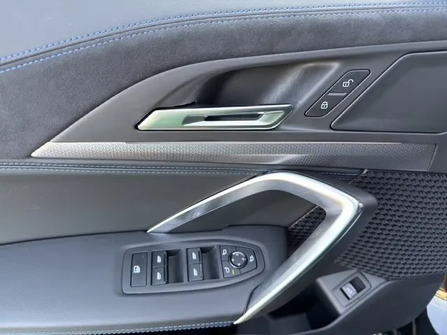 Détail de la porte côté conducteur de la BMW X2 sDrive20d M Sport 2025 noire, avec commandes de vitres et verrouillage.