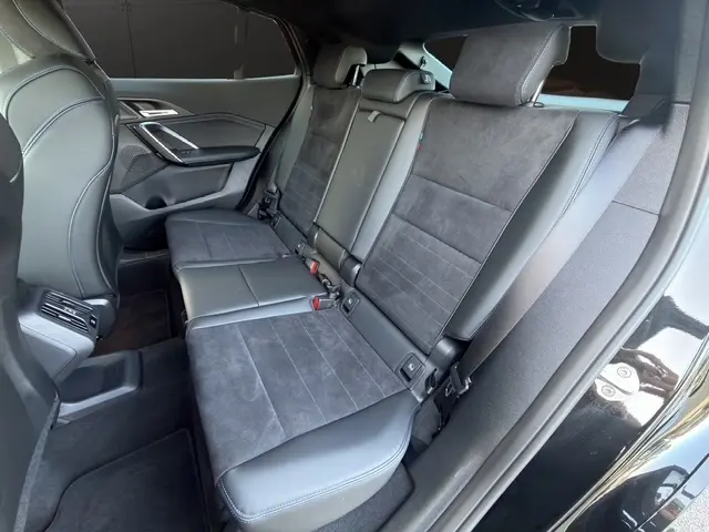 Vue intérieure côté droit de la banquette arrière en cuir et alcantara gris foncé du BMW X2 sDrive20d M Sport noir 2025.